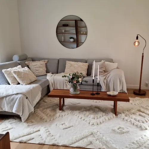 Renoverat vardagsrum med grå soffa och vit matta